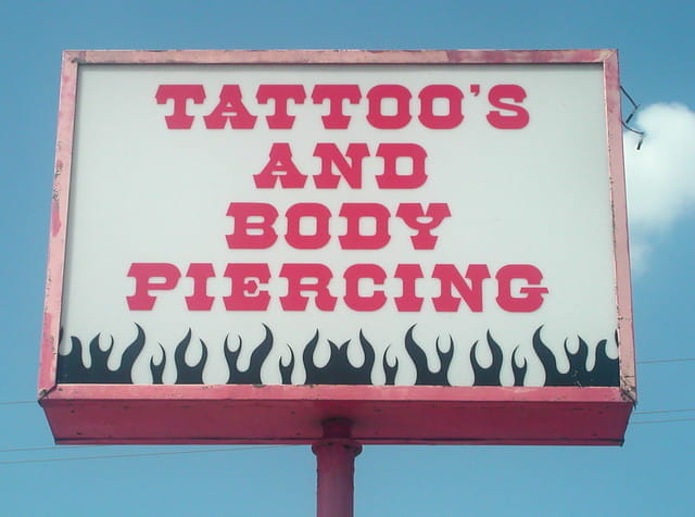 Example of an incorrect apostrophe used for plurals: Tattoo's and body piercing.